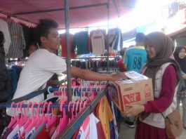 Volunteer STF UIN Jakarta Galang Dana Bantu Korban Selat Sunda Pedagang sedang memberikan donasinya ke dalam kotak donasi melalui volunteer yang sedang menggalang dana untuk korban bencana Tsunami Selat Sunda. Kegiatan Berlangsung di Pasar Pagi kampus II UIN Jakarta pada 30 Desember 2018.
