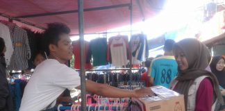 Volunteer STF UIN Jakarta Galang Dana Bantu Korban Selat Sunda Pedagang sedang memberikan donasinya ke dalam kotak donasi melalui volunteer yang sedang menggalang dana untuk korban bencana Tsunami Selat Sunda. Kegiatan Berlangsung di Pasar Pagi kampus II UIN Jakarta pada 30 Desember 2018.